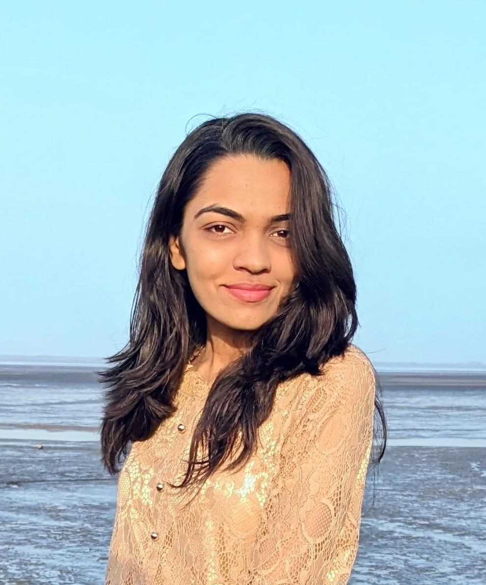 Kinal Gajera - Lead Product Designer and UI/UX Expert, smiling in a red plaid shirt and tortoise shell glasses